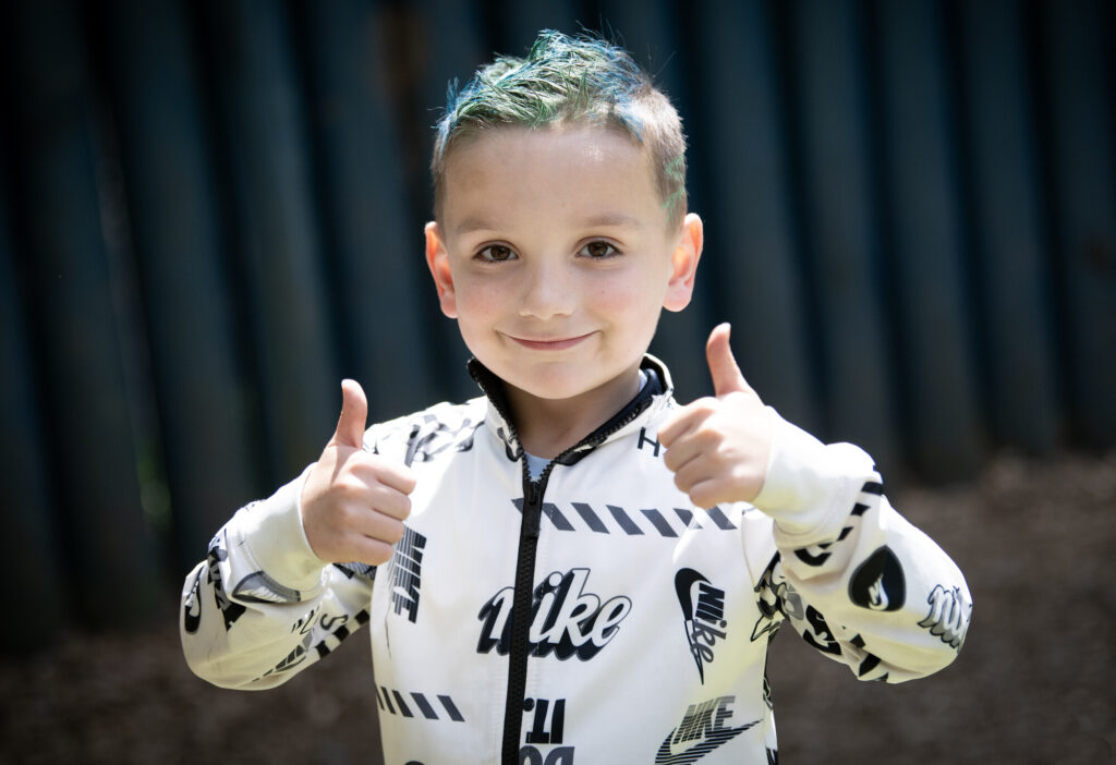 Little boy, smiling with 2 thumbs up