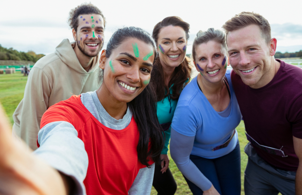 Group of adults outdoors, smiling at the camera.
