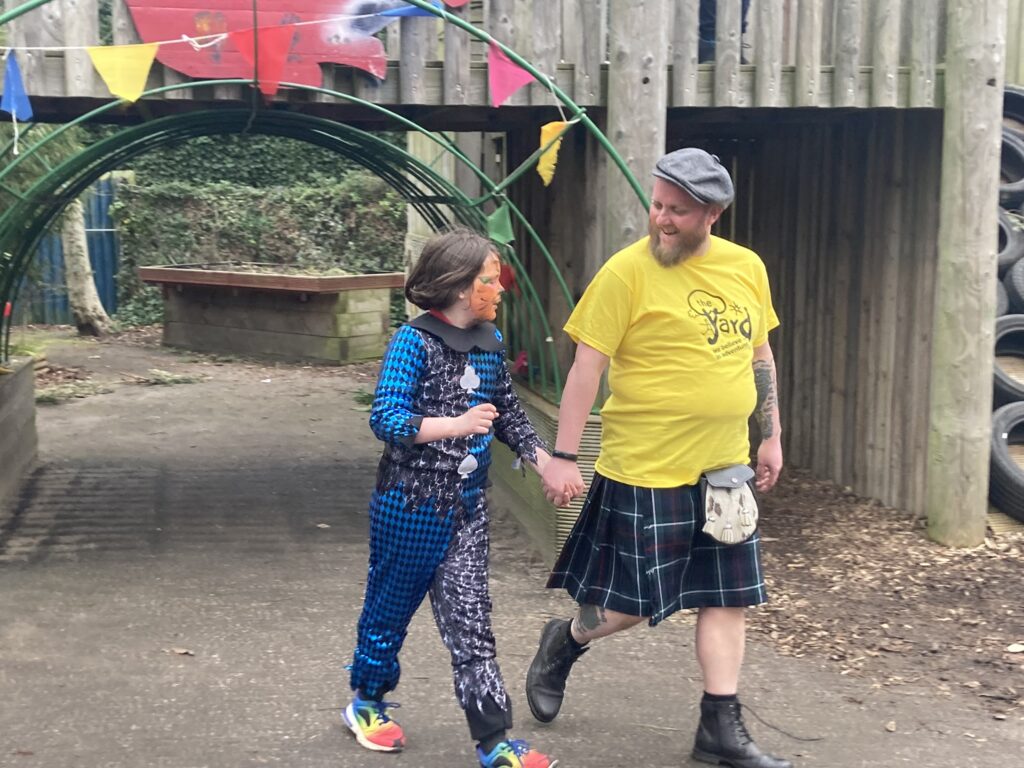 Fraser Gow in his kiltwalk smiling with child