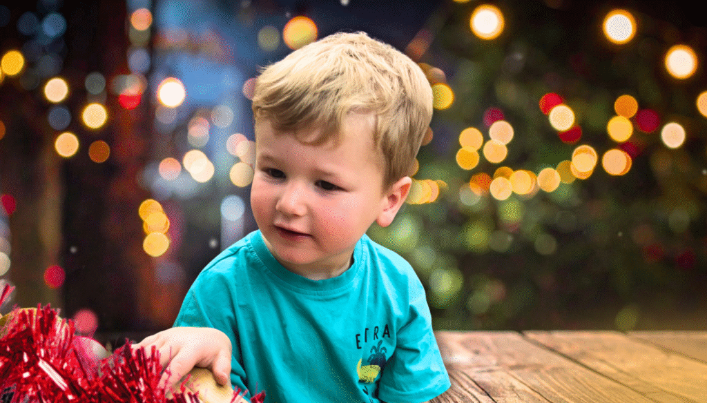 Christmas appeal photo, young boy with festive lights background