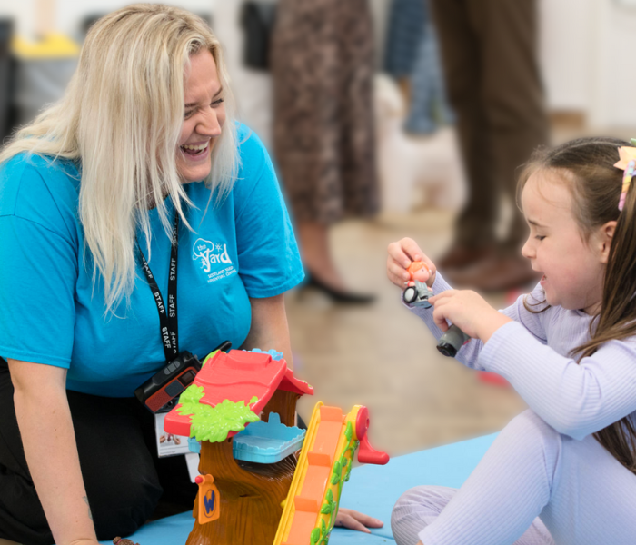 Playworker and little girl playing with toys to support the Christmas appeal